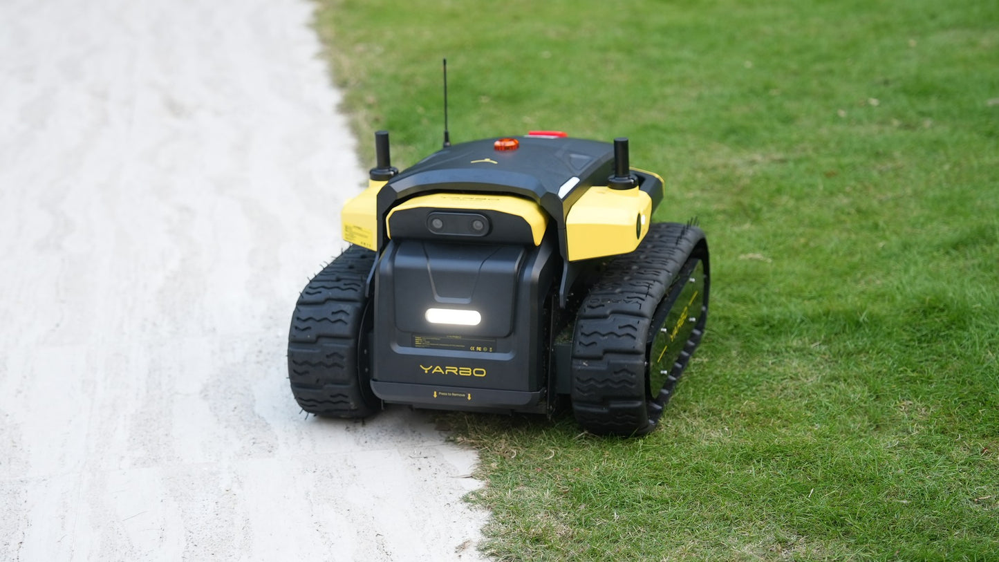 Yarbo Core crossing rough ground on its rubber tracks