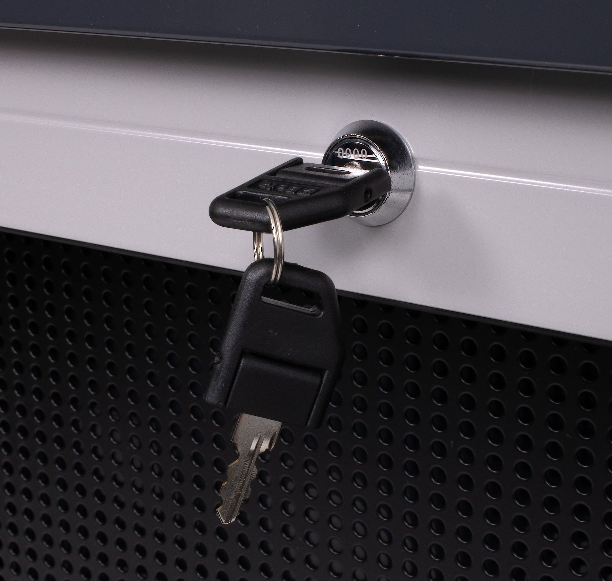 Close-up of the C57SP shutter lock with keys fitted, against the perforated tool board