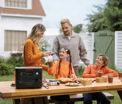 Family having breakfast in a backyard with the Explorer 1500 v2 powering a hot plate on the table