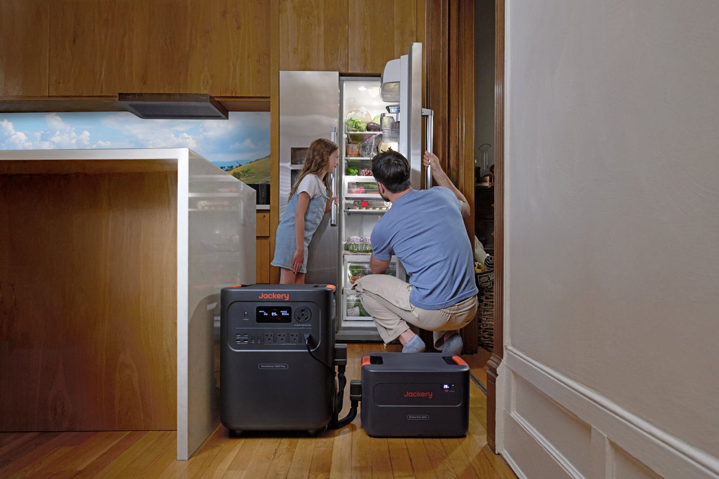 Father crouching to help daughter reach fridge items, HomePower 3600 Plus and Battery Pack on kitchen floor