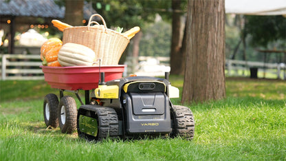 Yarbo Core towing a loaded garden wagon along a tree-lined path